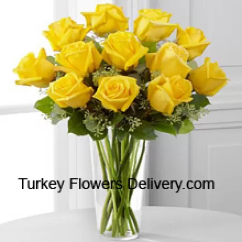 12 Rosas Amarillas con Algunos Helechos en un Jarrón de Cristal